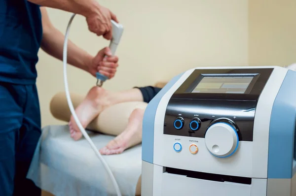Shock wave therapy. The magnetic field, rehabilitation. Physiotherapist doctor performs surgery on a patients heel — Stock Image Shock Wave Therapy Magnetic Field Rehabilitation Physiotherapist Doctor Performs Surgery Royalty Free Stock Photos
