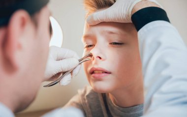 Otolaryngologist nasolar dilatator ile çocuk burun inceliyor. Tıbbi donatımı