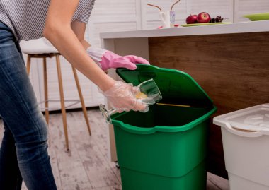 Mutfakta çöpleri ayıran genç bir kız. Geri dönüşüm kavramı. Sıfır atık