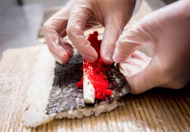 Restoranın mutfağında suşi ve ekmek yapma süreci. Şefin elleri bıçaklı..