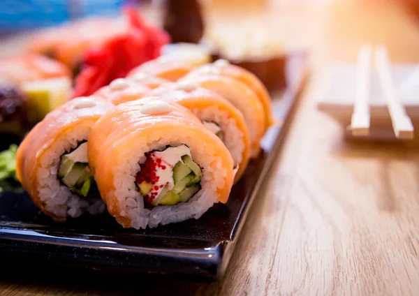 Sushi set. Rolls with salmon, eel and red caviar on a wooden plate. Restaurant. — Stock Photo, Image