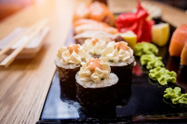 Sushi set. Rolls with salmon, eel and red caviar on a wooden plate. Restaurant. — Stock Photo, Image