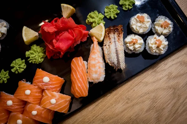 Sushi set. Rolls with salmon, eel and red caviar on a wooden plate. Restaurant. — Stock Photo, Image