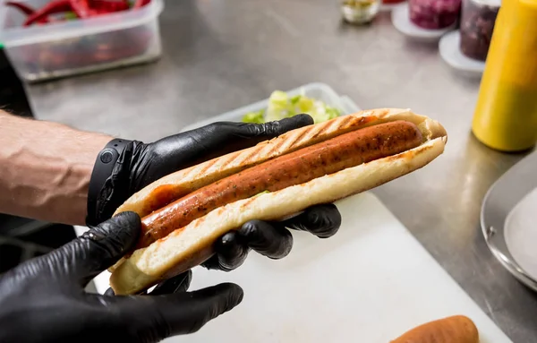 Šéfkuchař vaří hot dog na grilu. Restaurace. — Stock fotografie