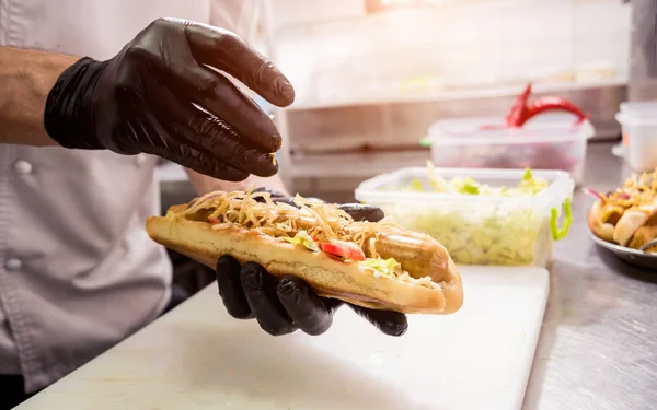 Le chef cuisinier hot dog sur un gril. Restaurant . — Photo
