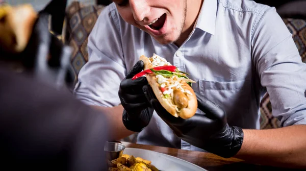 Deux jeunes hommes affamés mangeant des hot-dogs dans un café. Restaurant — Photo