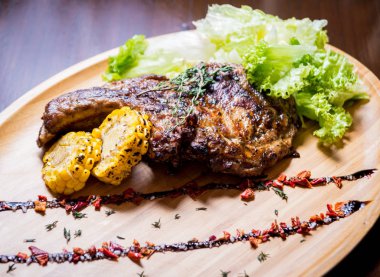 Tahtada mısır ve salata ile ızgara domuz pirzolası. Baharatlı Amerikan yemeği. Restoran.