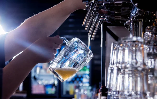 A csapos sört öntött a poharakba a bárban. Étterem. — Stock Fotó