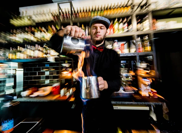 O barman faz um cocktail com um show de fogo no bar. Empregado de bar no trabalho. Um restaurante. Vida noturna — Fotografia de Stock