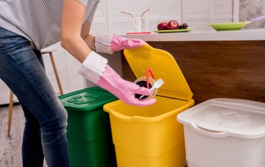 Mutfakta çöpleri ayıran genç bir kız. Geri dönüşüm kavramı. Sıfır atık