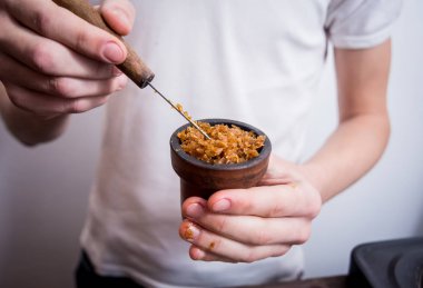 Barda nargile pişirmek. Bir kaseye tütün kesiyorum. Restoran, nargile barı, tüten kafe..