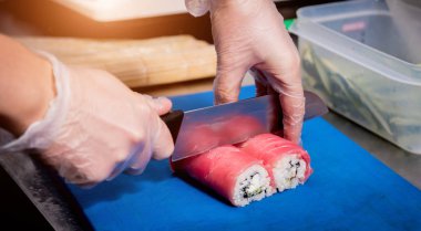 Restoranın mutfağında suşi ve ekmek yapma süreci. Şefin elleri bıçaklı..