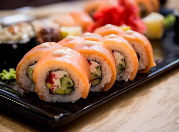 Sushi set. Rolls with salmon, eel and red caviar on a wooden plate. Restaurant. — Stock Photo, Image