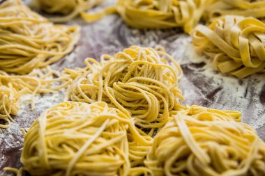 Homemade pasta on a wooden background. Italian style cuisine. Restaurant.