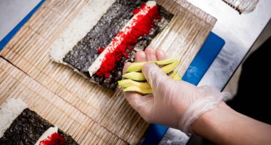 Restoranın mutfağında suşi ve ekmek yapma süreci. Şefin elleri bıçaklı..