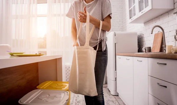 Menina segurando um saco de pano. Na cozinha. Não sou de plástico. Campanha para reduzir o uso de sacos plásticos. Resíduos zero — Fotografia de Stock