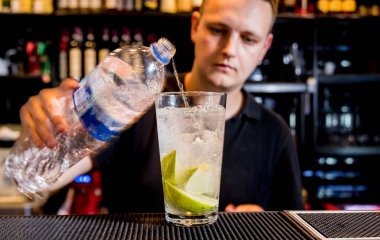 Barmen barda kokteyl hazırlıyor. Taze kokteyller. İş yerindeki barmen. Restoranda. Gece hayatı..