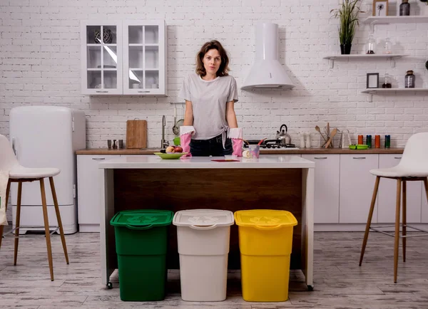 Молода дівчина сортує сміття на кухні. Концепція переробки. Нульові відходи — стокове фото