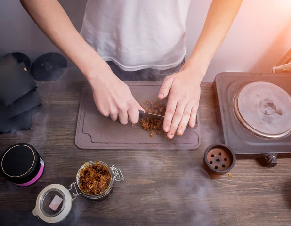 Matlagning hookah i baren. Skär tobak i en skål. Restaurang, krogbar, rökcafé. — Stockfoto