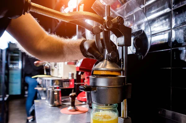 金属手动榨汁机。 鲜榨橙汁的制备 — 图库照片