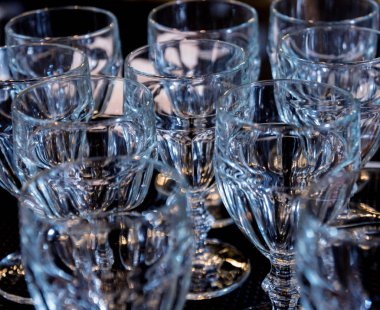 Restorandaki barın üstündeki rafta şarap ve martini bardakları var. Barda boş temiz bardaklar.