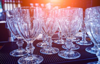 Restorandaki barın üstündeki rafta şarap ve martini bardakları var. Barda boş temiz bardaklar.