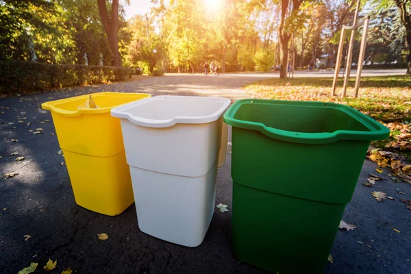 Trzy pojemniki na śmieci w innym kolorze, do sortowania odpadów. Na zewnątrz w strefie parkowej. Koncepcja zerowej ilości odpadów — Zdjęcie stockowe