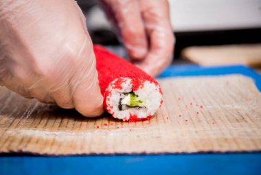 Restoranın mutfağında suşi ve ekmek yapma süreci. Şefin elleri bıçaklı..