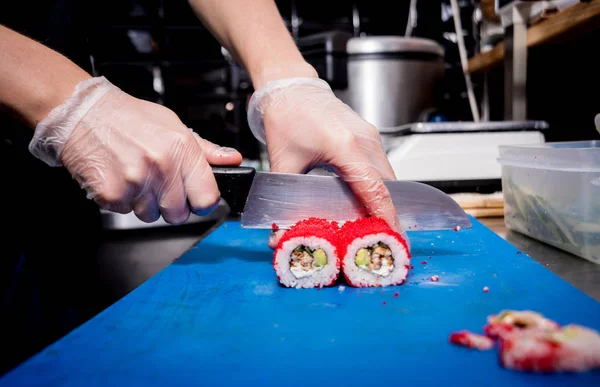 Restoranın mutfağında suşi ve ekmek yapma süreci. Şefin elleri bıçaklı..
