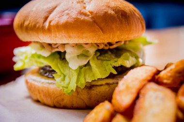 Tahta masada lezzetli çizburger ve patates kızartması. Restoran.