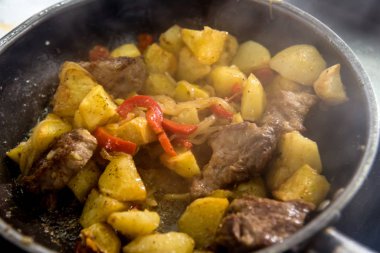 Şef, restoranın mutfağında kızarmış patates pişiriyor.