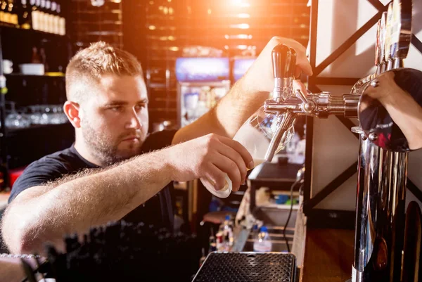 Barman schenkt bier in bij glazen in de bar. Restaurant. — Stockfoto