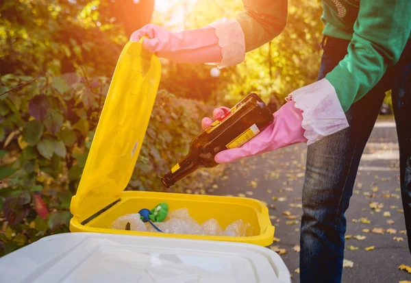 Volunteer girl sorts garbage in the street of the park. Concept of recycling. — ストック写真