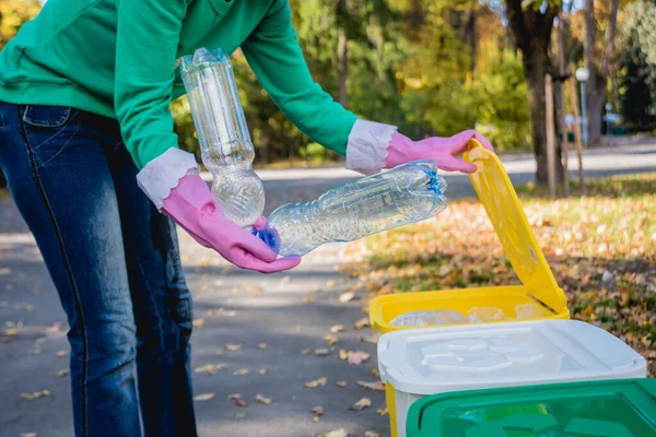 Volontär flicka sorterar skräp på gatan i parken. Begreppet återvinning. — Stockfoto