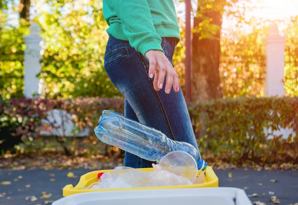 Volunteer girl sorts garbage in the street of the park. Concept of recycling. — Stock Photo, Image