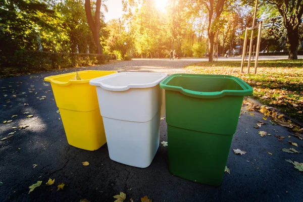 Three trash containers in different color, for sorted waste. Outdoors — ストック写真