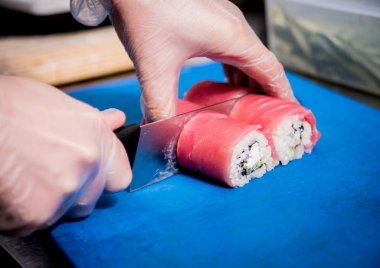 Restoranın mutfağında suşi ve ekmek yapma süreci. Şefin elleri bıçaklı..