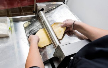 Şef makarna makinesiyle hamur topluyor. Makarna makinesi. 