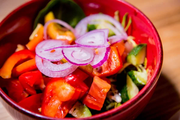 Ensalada de verduras frescas en plato rojo sobre la mesa de madera. Restaurante . —  Fotos de Stock