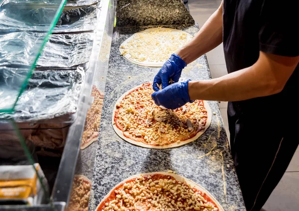 The process of making pizza. Hands of chef baker making pizza at cafe kitchen — Stock Photo, Image