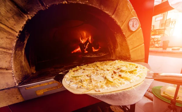 Pizza yapma süreci. Şef fırıncı çiğ pizzayı fırına koyar. Mutfak.. — Stok fotoğraf