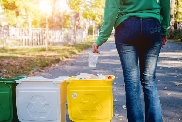 Volunteer girl sorts garbage in the street of the park. Concept of recycling. — ストック写真