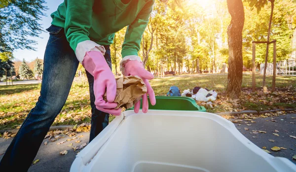 Volunteer girl sorts garbage in the street of the park. Concept of recycling — ストック写真