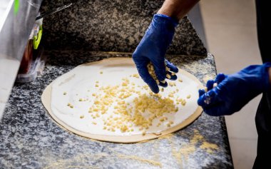 Pizza yapma süreci. Kafe mutfağında pizza yapan aşçının elleri.