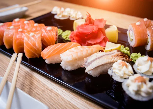 Sushi set. Rolls with salmon, eel and red caviar on a wooden plate. Restaurant. — Stock Photo, Image