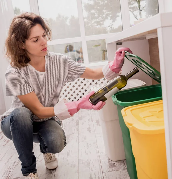 Een jong meisje dat afval sorteert in de keuken. Concept van recycling. Geen afval — Stockfoto