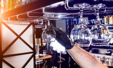 Barmen bardaki şarap bardaklarını siler. Restoran.