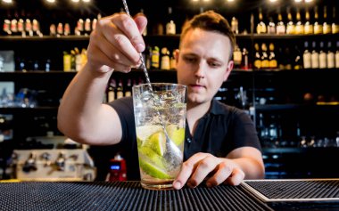 Barmen barda kokteyl hazırlıyor. Taze kokteyller. Barmen iş başında.. 