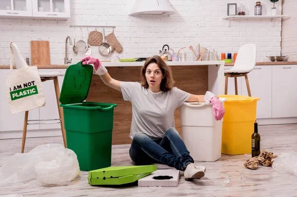 Young girl sorting garbage at the kitchen. Concept of recycling. Zero waste