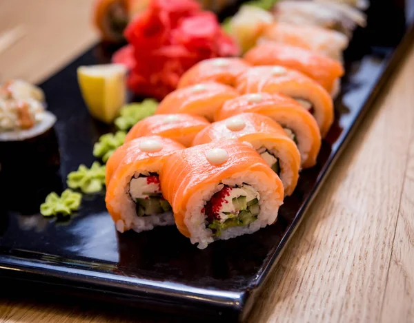 Sushi set. Rolls with salmon, eel and red caviar on a wooden plate. Restaurant. — Stock Photo, Image